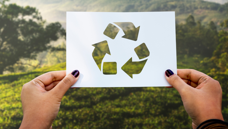 Kartka z sybolem recyglingu na tle krajobrazu